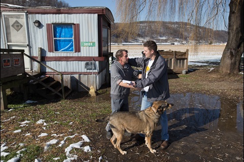 Wayne Worth (right) embraces Roger outside his home in Fisher, W.Va. Worth, a member of United Methodist Temple in Clarksburg, was passing out flyers containing information about local resources for anyone struggling with addiction when he met Roger. Photo by Mike DuBose, UM News.